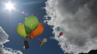 Ballons with papers attached taking off into the air